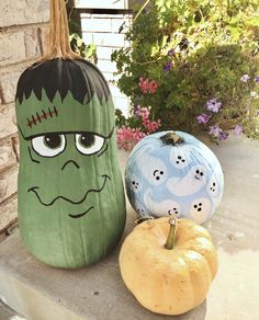 two pumpkins with faces painted on them sitting next to each other