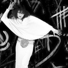 a woman in white is posing with her hands on her head