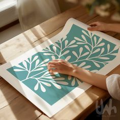 a person is making a paper art work on a table