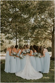 a group of bridesmaids standing in front of a tree