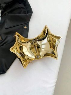 a black jacket and some gold objects on a white surface