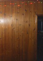 a room with wood paneling and christmas lights