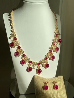 Ruby Necklace and Matching Earrings Set Necklace: 18 pcs. of Ruby from Africa, with 178 pcs. multi-shaped White Zircon, and tiny pieces of Pink Topaz on 92.5 Silver with golden niello ware setting.  Color/ Shape of Ruby: Purplish Red/ Oval Dimension: 18.5" long, 2" extender chain Dimension of the middle dangling part: 1.5" long Total Weight : 86.79 g. (with setting) Earrings: 1 pc. of Ruby and 2 pcs. of White Zircon on each with tiny pieces of Pink Topaz on 92.5 Silver with golden niello ware se Luxury Jewelry Sets With Round Jewels, Luxury Round Jewels Jewelry Sets, Luxury Jewelry Sets With Sparkling Stones, Elegant Ruby Jewelry Sets With Matching Earrings, Luxury Hand Set Ruby Jewelry Sets, Luxury Gemstone Jewelry Sets For Celebration, Teardrop Ruby Jewelry In Yellow Gold, Elegant Gold Jewelry Sets With Ruby, Luxury Hallmarked Ruby Jewelry