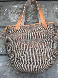 Kiondo overviewA beautiful Multicored hand bag made of fine weave sisal.It has a zipper and lining.The bag is made of sisal fiber that is hand picked hand prepared into yearn then twisted and weaved. It is finished with natural leather mainly from cow hide.UsesThe bag is extra large in size that can accommodate overnights clothes and other personal effects.Day out: Its a great bag for use in carrying personal effects such as outdoor mats ,sandals and other picnic itemsShopping: The bag has large Beach Woven Hobo Bag With Top Handle, Woven Top Handle Hobo Bag For Beach, Beach Woven Top Handle Hobo Bag, Beach Hobo Bag With Leather Top Handle, Beach Hobo Bag With Top Handle And Leather Details, Natural Leather Basket-shaped Bucket Bag, Natural Leather Basket Bucket Bag, Top Handle Hobo Bag With Leather Handles For Beach, Natural Leather Crochet Top Handle Bag