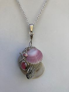 "Natural sea shell pendant necklace, ocean shells clustered with all different types of shells, with a Starfish and Sand dollar charms on a Sterling plated 20\" loop chain and Sterling bail. Unique seashell pendant measures 2 3/4\" X 1 1/4'' You can compare the size of the shells to the $0.50 cent piece in the pictures. All my necklaces are different and would be considered one of a kind. View my collection of Kingman Arizona Turquoise here: https://www.etsy.com/shop/MoonwaterJewelryShop?section_id=28192591  I've been selling on eBay since 2003 Came to Etsy to sell jewelry. Returns and exchange details ► RETURNS / EXCHANGES All items are handcrafted and custom pieces therefore we don't usually accept returns or exchanges on jewelry unless the fault was ours. Screens do not always reflect t Ocean-inspired Pendant Necklace With Lobster Clasp, Ocean-inspired Dangle Charms Jewelry, Ocean-inspired Silver Charms Jewelry, Ocean-inspired Charms For Jewelry Making, Silver Charm Necklace With Dangling Charms, Unique Silver Charm Necklace With Dangling Charms, Ocean-inspired Shell Charm Necklace With Lobster Clasp, Beach Starfish Charms Necklaces, Beach Charms Starfish Necklace