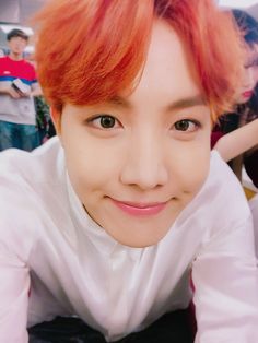 a young man with red hair wearing a white shirt and black bow tie smiling at the camera