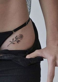 a woman's stomach with a rose tattoo on it