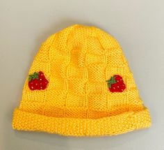 This is a handmade knit hat with a basket weave pattern. The hat is  yellow and made to fit a child 3 years and up.There are three embroidered strawberries spaced evenly around the hat. A strawberry can be seen from every angle. If you are interested in a different color hat or embroidery, please feel free to let me know. I love doing custom orders!Little ones will stay warm outside all day long! Casual Yellow Crochet Hat Hand Knitted, Casual Yellow Handmade Crochet Hat, Casual Yellow Crochet Hat, Yellow One Size Fits Most Beanie, Adjustable Yellow Knitted Hat, Yellow Crochet Cap Hat, Yellow Yarn Crochet Cap, Cute Yellow Winter Hat, Yellow Crochet Yarn Cap