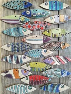 a group of colorful fish sitting on top of a wooden table next to each other