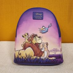 As Far As The Light Shines Is Your Kingdom When You Bring This Sweet Lion King Bag On Your Next Adventure! Make This The Perfect Gift For That Special Someone.... Or Just Treat Yourself! * * * * Features * * * * * Height 10" * Width 4" * Length 9" * Top Handle 3" * Adjustable Straps * Zip Closure * Brass Hardware * Faux Leather Exterior * No Exterior Pockets * Interior Is Purple Cloth * Inside Has 1 Pouch * By Loungefly & Disney * New With Tags Make This Your New Favorite Bag! Themed Purple Travel Bags, Disney Purple Travel Backpack, Disney Purple Backpack, Purple Disney Backpack, Purple Backpack For Disney Trips, Lion King Mufasa, Purple Cloth, Disney The Lion King, Loungefly Bag