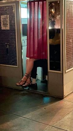 a woman is standing in a phone booth