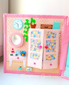 a close up of a doll's house made out of paper and fabric with a clock on the wall