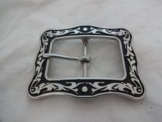 A new buckle from Horse Shoe Brand Hardware, designed by Jeremiah Watt. A stainless steel square buckle in the black Floral pattern.The measurements reflect the size of material that the buckle and tip will fit on to (the length measured from inner edge to inner edge).  For example, the 1 1/2" set will fit an 1 1/2" wide piece of material. Classic Black Belt Buckles With Silver Buckle, Western Black Belt Buckles With Silver Detail, Western Black Belt Buckles With Silver Buckle, Black Western Belt Buckles With Silver Buckle, Classic Black Concho Belt Buckles, Classic Black Rectangular Belt Buckles, Black Floral Pattern, Western Belt Buckles, Western Belt