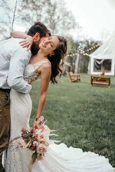 a bride and groom kissing in the grass