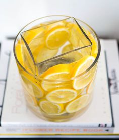 a glass filled with lemon slices on top of a table