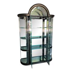 a tall glass display case with mirrors on it's sides and an arched top