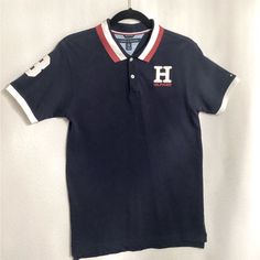 Tommy Hilfiger, Boys (Juniors), Logo Polo Shirt, Size: 20, Color: Navy Blue, Condition: Brand New, Unused, Pullover, Collar, Short Sleeves Material: Cotton, Polyester, Machine Washable, Logo On Chest Of Polo Shirt Blue Collared Tops For College, Blue Polo Collar Top For School, Blue Polo Collar Top For Streetwear, Blue Cotton Polo Shirt With Graphic Print, Blue Casual Polo Shirt For School, Casual Blue Polo Shirt For School, Blue Casual School Polo Shirt, Navy Cotton Top For College, Navy Cotton Tops For College