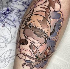 a tattoo on the leg of a person with an animal and flower design around it