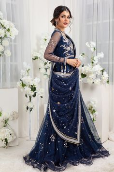 Glistening & Gleaming kamdani embellishments over midnight blue hue, a versatile floor-length gown with zardozi work on bodice finished with delicate ruffles & gota details. This look is completed with draped heavily embellished dupatta. Gown Fabric: Net & Silk Net Gown Length: 60” (customisable mention in order notes) Dupatta Fabric: Net (not stitched to outfit) Gown & Dupatta color: Midnight Blue This is a two-piece outfit including gown & Draped dupatta. All outfits are fully lined Lining in Eid Evening Pre-draped Saree With Resham Embroidery, Designer Party Wear Pre-draped Saree For Eid, Hand Embellished Organza Pre-draped Saree, Evening Pre-draped Saree With Mirror Work For Eid, Elegant Embellished Chanderi Lehenga, Semi-stitched Evening Dress With Sheer Dupatta, Anarkali Style Pre-draped Organza Saree For Eid, Elegant Chanderi Evening Sets, Eid Embellished Organza Anarkali Set