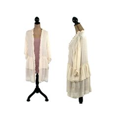 These semi sheer, lightweight rayon dusters come in your choice of cream, mauve, green or light gray. They are open style with romantic ruffles and can be worn as a jacket, robe or beach cover up. The cardigan has 3/4 sleeves and a hippie boho vibe. Each piece in our HEART ALTERED collection has been embellished with our signature ♥ charm. 100% rayon Hand wash, hang dry Measurements: Small ~ Shoulders ~ 23 inches Sleeve length ~ 10-1/2 inches Bust ~ 44 inches Hips ~ 54 inches Length from top of Lightweight Open Front Outerwear For Spring, Lightweight Long Sleeve Outerwear For Spring, Flowy Long Sleeve Spring Outerwear, Cream Open Front Outerwear For Layering, Summer Long Sleeve Lagenlook Cardigan, Cream Long Sleeve Cardigan For Summer, Feminine Spring Outerwear For Layering, Cream Long Sleeve Summer Cardigan, Bohemian Cream Outerwear For Layering