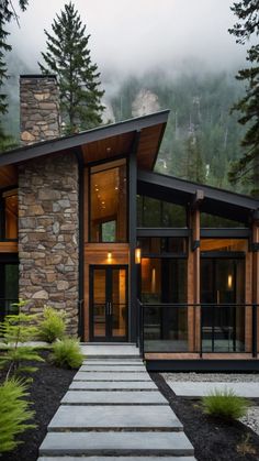 a stone and wood house in the mountains with stairs leading up to it's entrance