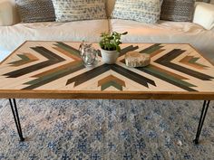 a coffee table with a potted plant on it in front of a white couch