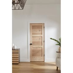 an open door in a white room with wooden floors and drawers on either side of the door