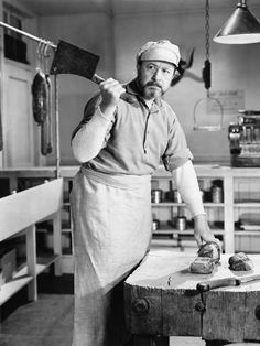 an old black and white photo of a man working in a shoe factory with his hammer