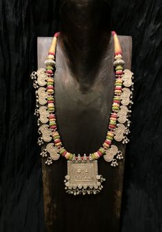 Get lost in the detail and unique beauty of antique silver Banjara beads strung onto a beautifully woven cord, handcrafted in India. All of our jewelry is one of a kind, handmade, and fair trade. A truly one of a kind piece, this necklace features the breathtaking intricacy of century old Banjara silverwork which is gracefully contrasted by the colorful and intricate woven cord they’re strung upon. The Banjara are one of the ancient nomadic tribes in India and have been known for centuries for t Red Sterling Silver Necklace With Oxidized Finish, Silver Multi-stone Temple Jewelry Necklace, Unique Pink Festive Jewelry, Silver Temple Jewelry With Multi-stone, Multicolor Sterling Silver Temple Jewelry Necklaces, Fusion Multi-stone Pink Jewelry, Pink Multi-stone Necklace For Gift, Pink Multi-stone Necklace As Gift, Pink Multi-stone Necklaces For Gifts