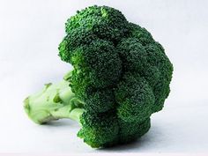 a piece of broccoli sitting on top of a white surface