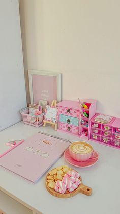 there is a pink desk with many items on it, such as cookies and other things