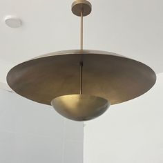 a light fixture hanging from the ceiling in a room with white walls and flooring