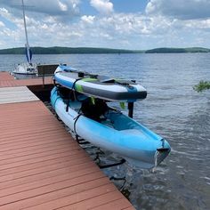 an inflatable kayak tied to a dock at the edge of a body of water