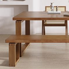 a wooden table with two benches in front of it and a vase on the other side