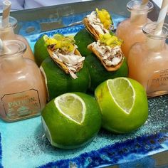 some limes are sitting on a tray with drinks