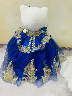 Celebrate your special day with the Hello Kitty Quinceañera dress. Made from tulle and adorned with gold appliques, this dress is fully customizable to help you stand out. Combining elegance and playfulness, this dress is perfect for any Hello Kitty fan looking to make a statement. Gold Princess Pageant Dress For Dress-up, Royal Blue Princess Dress For Wedding, Princess Style Gold Gown For Dress-up, Festive Gold Tulle Dress, Gold Embellished Ball Gown For Pageant, Gold Ball Gown For Fancy Dress, Gold Embellished Tulle Dress, Elegant Gold Tulle Gown, Festive Princess Dress In Gold