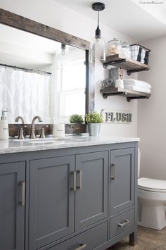 a bathroom with gray cabinets and a white toilet