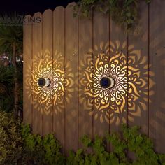 two decorative lights on the side of a wooden fence