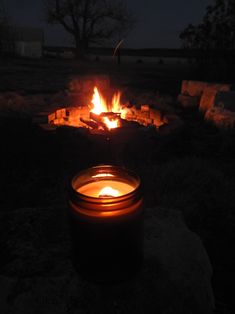 a lit candle sitting in front of a fire pit