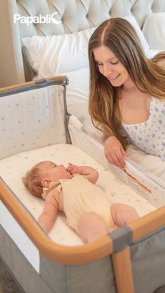 a woman laying in bed next to a baby