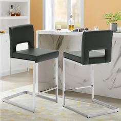 two black and white chairs sitting in front of a counter