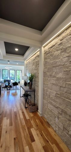 a living room with hard wood floors and stone walls