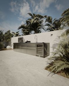 a modern outdoor kitchen with palm trees in the backgrounnd and blue sky