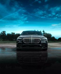 the front end of a mercedes s - class sedan parked in a parking lot at night