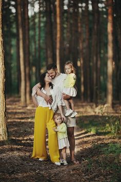 a family poses for a photo in the woods