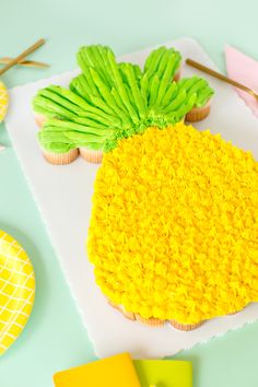 cupcakes decorated with green and yellow frosting on top of a paper towel