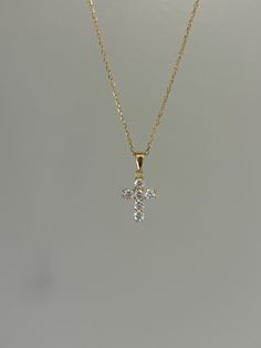 Dainty and so sparkly, this cross necklace is a must-have! You will shine at every step that you take. Information: ✨ Sterling Silver (925 stamped) | 14K Gold Plated ✨ AAA grade Cubic Zirconia gemstones ✨ Adjustable length: 16" - 18" ✨ Hypoallergenic ✨ Tarnish resistant ✨ Water friendly Our cross necklace has an splendid level of craftsmanship and attention to detail, from the carefully set gemstones to the high polishing of the metal. Once you see the necklace, there is no doubt about the quality. Plus, the necklace is adjustable. You have the ability to wear it at 16", 17" or 18" allowing you to create various layering possibilities and find your best fit. For centuries, Christians have seen the cross as a symbol of their faith and divine protection. It makes a great talisman and gives y Diamond Cross Necklace Gold, Dainty Cross Necklace, Simple Gold Earrings, Cross Charm Necklace, Christian Necklace, Gold Cross Necklace, Dainty Gold Necklace, Gold Bracelet Cuff, Tiny Diamond