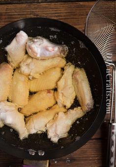 chicken is cooking in a skillet on the stove with a spatula next to it