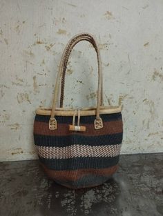 "Baobab bags are handwoven and the material used is from the bark of the Baobab tree that grows wild in Africa. These beautiful baobab baskets are made from Baobab tree bark, the fibers are harvested from the tree (this does not affect the tree, and the fibers grow back) then soaked for the fiber to be soft for weaving, it's then handwoven to make this gorgeous unique patterned bags. This baobab basket can be used as a storage basket,market basket, shopping basket, weekend basket bag, beach bag. Natural Basket Bag Fair Trade, Fair Trade Natural Basket Bag, Natural Basket-shaped Fair Trade Bags, Daily Use Fair Trade Crochet Basket Bag, Natural Fair Trade Basket Bag, Brown Jute Bucket Bag In Basket Shape, Brown Jute Basket-shaped Bucket Bag, Brown Jute Basket Bucket Bag, Eco-friendly Brown Straw Bag For Gifts