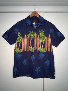 Hawaiian Reserve Collection shirt button down short sleeve. Awesome looking surfboard and palm trees themed shirt.   Size small (S) mens Made in Hawaii, USA 100% Cotton No Damage, no odor, clean.  Please message with any questions or for size measurements needed. All shirts are packed and shipped with quality materials. Tropical Button-up Hawaiian Shirt For Beach Season, Hawaiian Button-up Camp Shirt For Beach, Button-up Hawaiian Shirt With Palm Tree Print For Beach, Casual Hawaiian Shirt With Graphic Print For Surfing, Palm Tree Print Button-up Hawaiian Shirt For Beach, Beach Hawaiian Shirt With Palm Tree Print, Blue Camp Shirt With Palm Tree Print For Beach, Blue Palm Tree Print Camp Shirt For Beach, Hawaiian Graphic Print Surfing Shirt